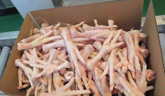 raw peel chicken feet inside brown carton box ready to freeze for export