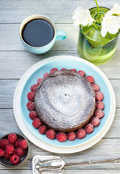 chocolate cake with raspberries and flowers chocolate cake with fresh raspberries and a coffee powdered sugar stock pictures, royalty-free photos & images