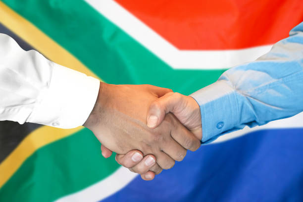 Business handshake on South Africa flag background. Men shaking hands and South Africa flag on background. Support concept