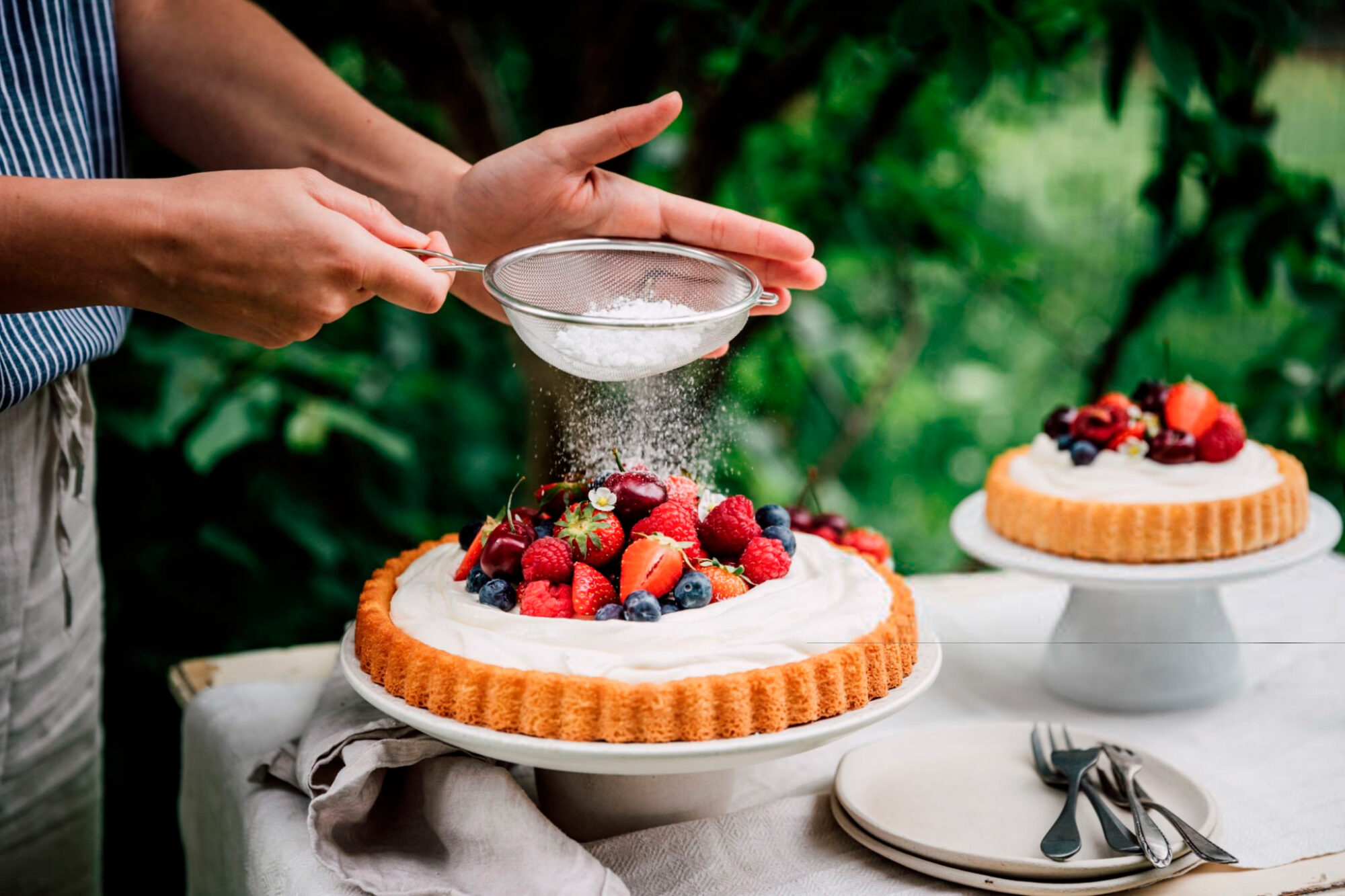 Woman preparing fresh fruits and berries cake