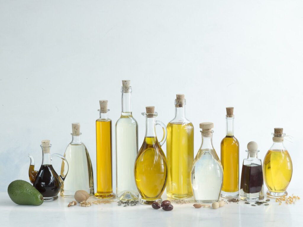 Various types of refined edible oils disposed with its origin grain to show up how oils are made and used for